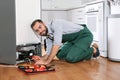 Male technician in uniform repairing refrigerator Royalty Free Stock Photo