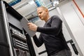 Male Technician Using Digital Tablet In Datacenter to Monitor SAN and Servers Royalty Free Stock Photo