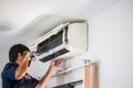 Male technician using a screwdriver fixing modern air conditioner, Male technician cleaning air conditioner indoors, Maintenance Royalty Free Stock Photo