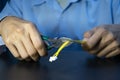 A male technician is using yellow wire cutters Royalty Free Stock Photo