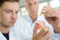 Male technician working on dentures with sharp tool Royalty Free Stock Photo