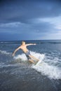 Male teen riding skimboard.