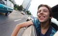 Male teenager in car enjoying city view