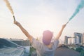 Male teenager holding colorful smoke sticks up in the air over u Royalty Free Stock Photo