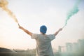 Male teenager holding colorful smoke sticks up in the air over u Royalty Free Stock Photo