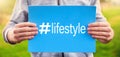Male teenager holds a banner with the word lifestyle against nature background. Youth lifestyle