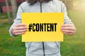 Male teenager holds a yellow banner with the word content message against nature background