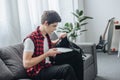 male teenager putting laptop into bag while sitting