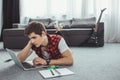 male teenager studying with copybook and laptop while lying Royalty Free Stock Photo