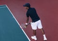 Male tennis player at baseline preparing to serve