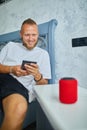 Male testing talking smart wireless speaker, man controlling home devices with a voice commands Royalty Free Stock Photo