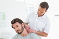 Male therapist massaging a young mans neck