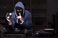 Male thief in balaclava in the office night time Royalty Free Stock Photo