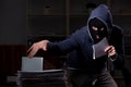 Male thief in balaclava in the office night time Royalty Free Stock Photo