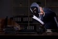 Male thief in balaclava in the office night time Royalty Free Stock Photo