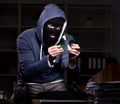 Male thief in balaclava in the office night time Royalty Free Stock Photo