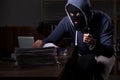 Male thief in balaclava in the office night time Royalty Free Stock Photo