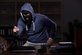 Male thief in balaclava in the office night time Royalty Free Stock Photo