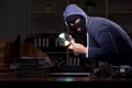 Male thief in balaclava in the office night time Royalty Free Stock Photo