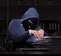 Male thief in balaclava in the office night time Royalty Free Stock Photo