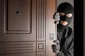 Male thief entering house through door at night Royalty Free Stock Photo