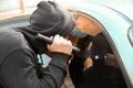 Male thief with flashlight looking inside car Royalty Free Stock Photo