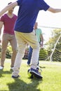 Male Three Generation Family Playing Football Together