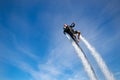 Thrillseeker, athlete strapped to Jet Lev, levitation soars into a blue sky with whispy clouds