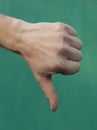 Male thumb down on green background Royalty Free Stock Photo
