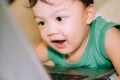 A male toddler is playing with a laptop while on the bed Royalty Free Stock Photo