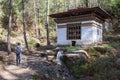 Male tourist in Bhutanese dress walks pass water power prayer Royalty Free Stock Photo