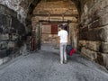 A male tourist enters the Ankara fortress Turkey through the ancient arched gate - view from the back. Tall young adult dark-