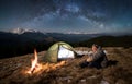 Male tourist have a rest in his camp at night under beautiful sky full of stars and milky way Royalty Free Stock Photo