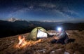 Male tourist have a rest in his camp at night under beautiful sky full of stars and milky way Royalty Free Stock Photo