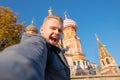 Male tourist makes selfie photo on background Saint Basil Cathedral Red Square in Moscow, Russia autumn Royalty Free Stock Photo