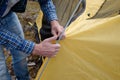 Male tourist making a tent at forest camp. Royalty Free Stock Photo