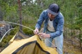 Male tourist making a tent at forest camp. Royalty Free Stock Photo