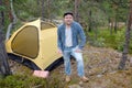 Male tourist making a tent at forest camp. Royalty Free Stock Photo