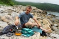 Male tourist relaxing on sea beach cooking food use portable camp stove at beautiful seascape