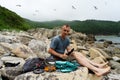 Male tourist relaxing on sea beach cooking food use portable camp stove at beautiful seascape