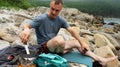 Male tourist relaxing on sea beach cooking food use portable camp stove at beautiful seascape