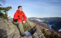 Male tourist sitting on rock on top of the mountain Royalty Free Stock Photo