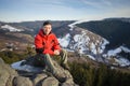 Male tourist sitting on rock on top of the mountain Royalty Free Stock Photo