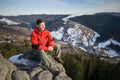 Male tourist sitting on rock on top of the mountain Royalty Free Stock Photo