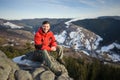 Male tourist sitting on rock on top of the mountain Royalty Free Stock Photo