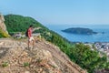 Male tourist stands on a mountain above Budva in Montenegro