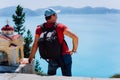 Male tourist staying near small Hellenic shrine Proskinitari admire seascape landscape. Amazing coatline view in the