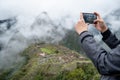 Male tourist taking photo of Machu Picchu