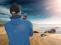 Male tourist taking picture on his smart phone of a beautiful beach, Selective focus, Concept travel, capture and share experience Royalty Free Stock Photo