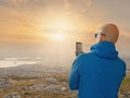 Male tourist taking picture on his smart phone of mountain landscape, Selective focus, Concept travel, capture and share Royalty Free Stock Photo